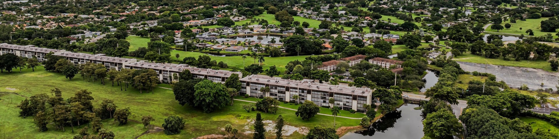 Aerial view of a suburban landscape with lush greenery under a cloudy sky. Lauderhill, Florida