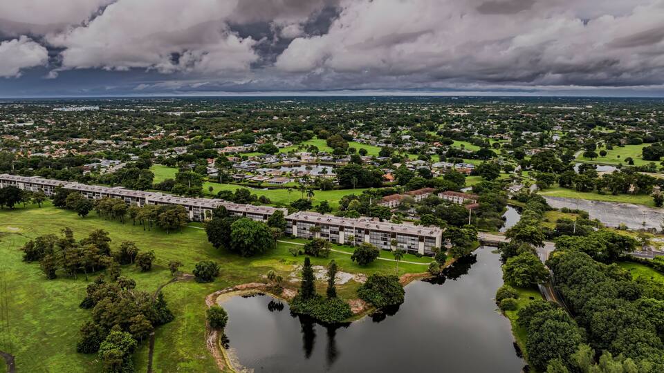 Aerial view of a suburban landscape with lush greenery under a cloudy sky. Lauderhill, Florida