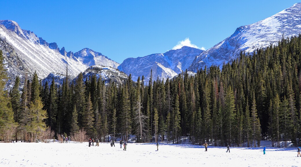 Frozen Bear Lake in Rocky Mountain National Park looking south. Hikers crossing the frozen lake on a cold March day.