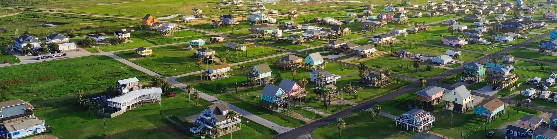 A coastal residential area with houses, roads, and a marina.
