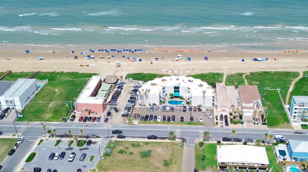 Panorama aerial view beach hotels, condos, vacation rental, resorts swimming pool along sandy shoreline, turquoise water in South Padre Island, tropical barrier island Texas Gulf Coast, travel