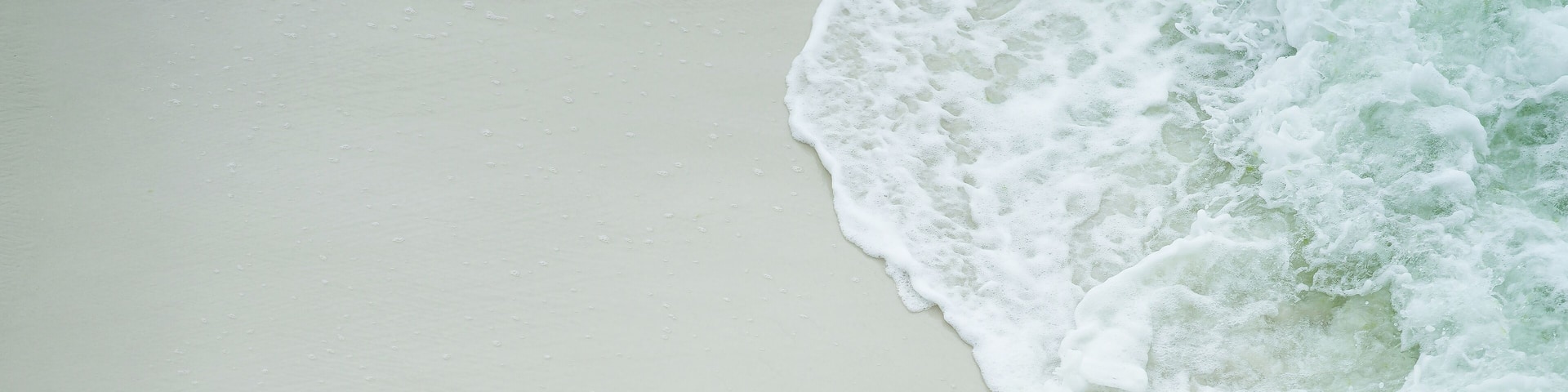 Turquoise Close up of a wave covering the white sand beach of Navarre, Florida, in Gulf of Mexico