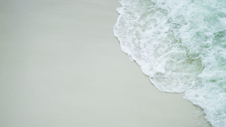 Turquoise Close up of a wave covering the white sand beach of Navarre, Florida, in Gulf of Mexico