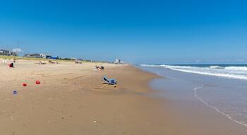 REHOBOTH, DELAWARE - USA - AUGUST 17, 2020: A relatively empty beach south of Rehoboth Beach on a sunny summer afternoon. Empty beach chair in foreground and town of Rehoboth in background.