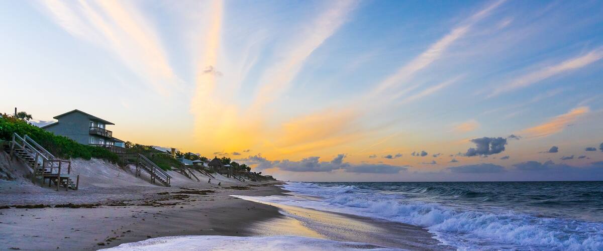 Orange clouds in the form of diverging rays at sunset on the ocean in Melbourne Beach, Florida