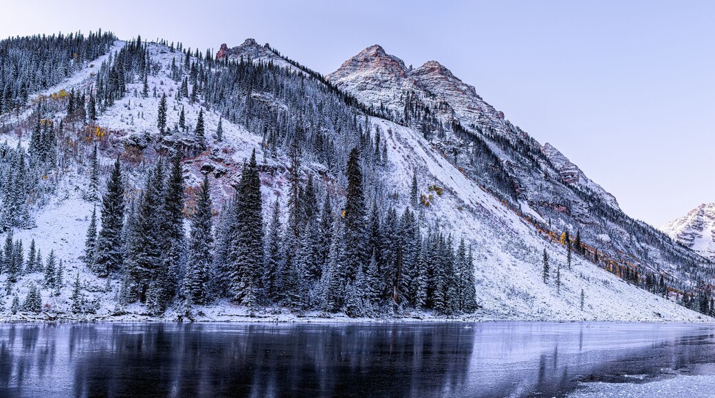 Maroon Bells morning sunrise panorama with sunlight on peak in Aspen, Colorado rocky mountain and autumn yellow foliage panoramic view winter snow