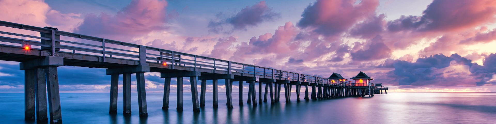 A scenic colorful sunset at the beach with a breathtaking boardwalk
