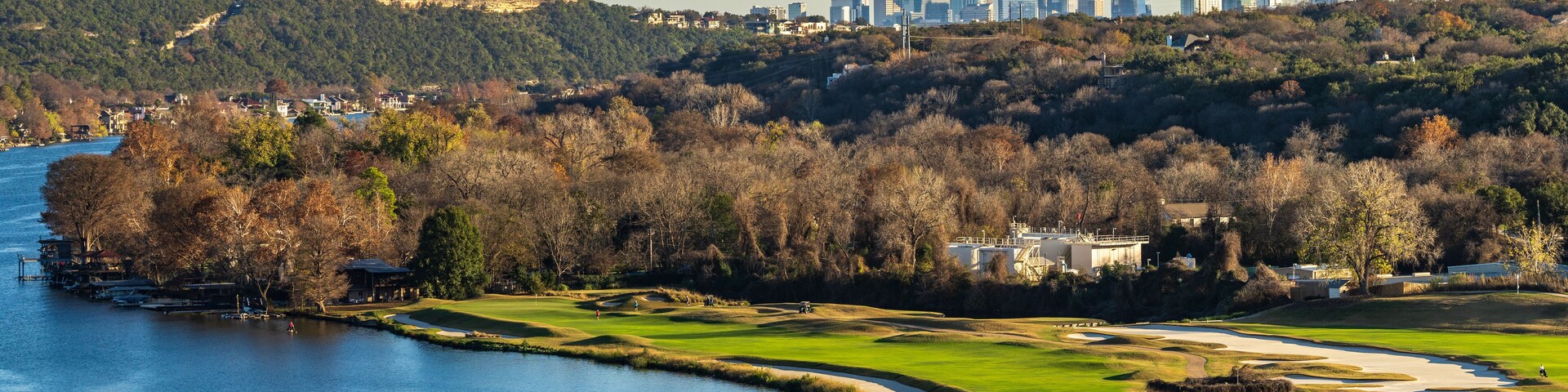 Golf course lines the Colorado river with downtown Austin Texas in distance from Pennybacker bridge overlook