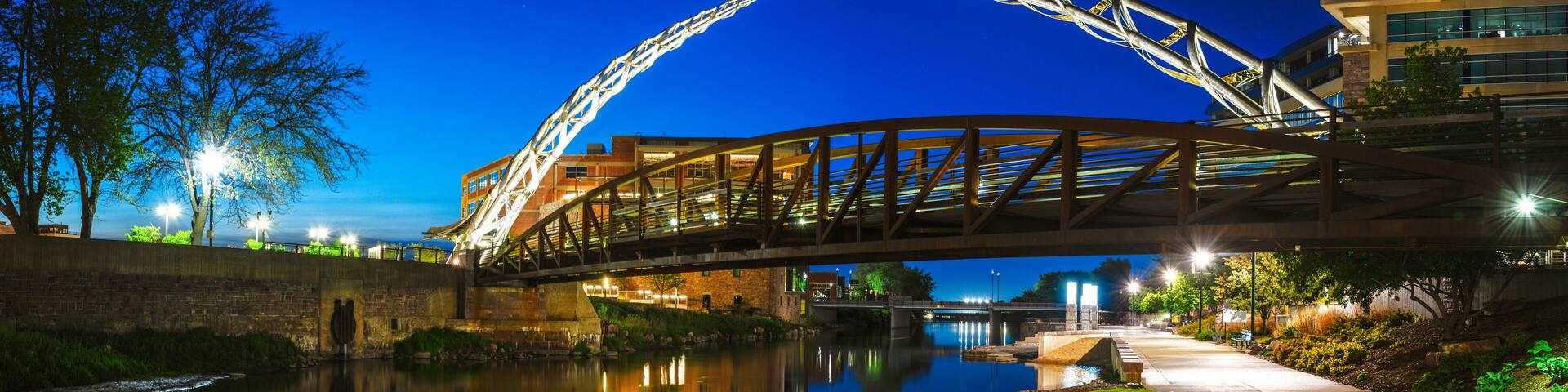 Sioux Falls Downtown River Greenway Lighted Trail, Skyline, Bridges, and Reflectoins on the Big Sioux River Water at Night in South Dakota, USA