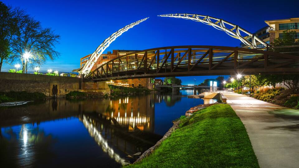 Sioux Falls Downtown River Greenway Lighted Trail, Skyline, Bridges, and Reflectoins on the Big Sioux River Water at Night in South Dakota, USA