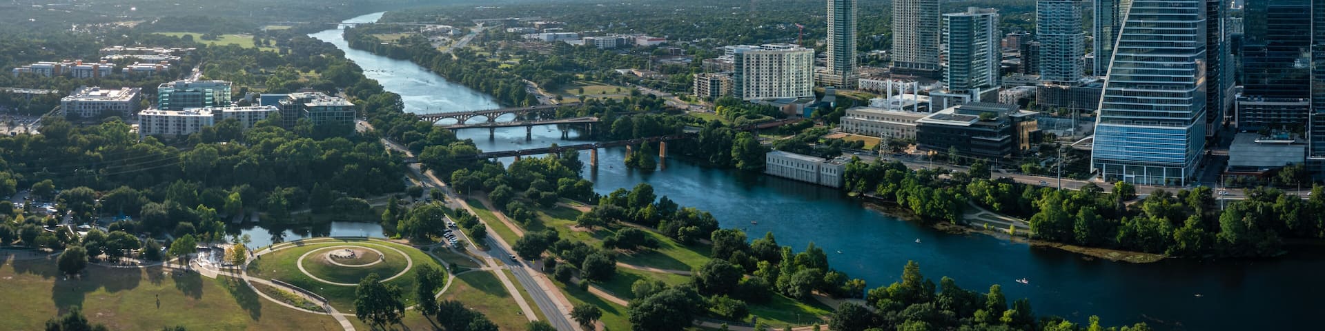 A river flowing through a city with modern skyscrapers and a bridge.