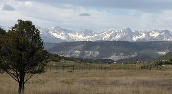 Ultra-wide panoramic view from Ridgway State Park of the San Juan Mountains on a stormy day in spring