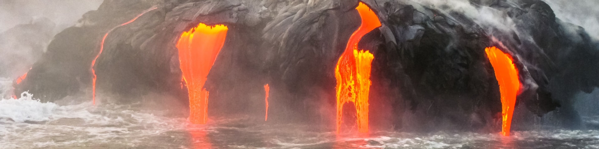 Close up of Kilauea Volcano, Hawaii Volcanoes National Park, also known Kilauea Smile because from 2016 seems to smile, erupting lava into Pacific Ocean, Big Island. Scenic sea view from the boat.