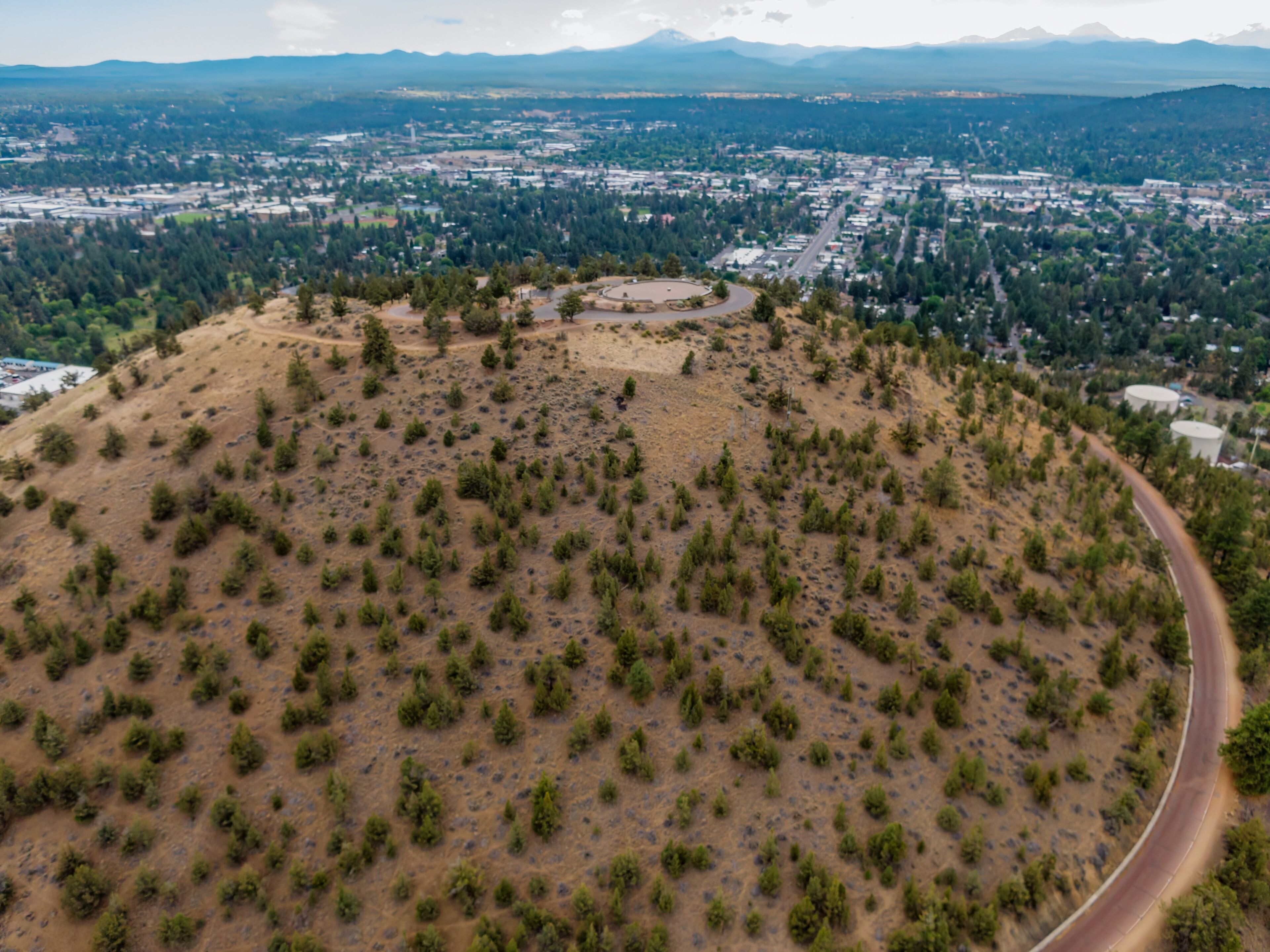 High-angle view of Pilot Butte Neighbourhood Park from a hilltop. City sprawls below, with mountains in the distance. ,Bend, Oregon, USA