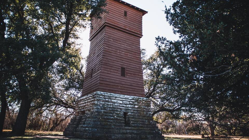 Historic water tower from the 1930s in a wooded area in the Abilene State Park in Texas, USA