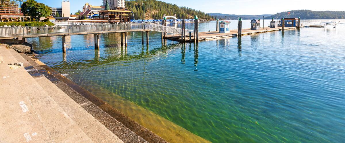 View from the City Beach Park of the wooden pier and jetty with seaplane and the downtown resort and Tubbs Hill, in Coeur d'Alene, Idaho USA.