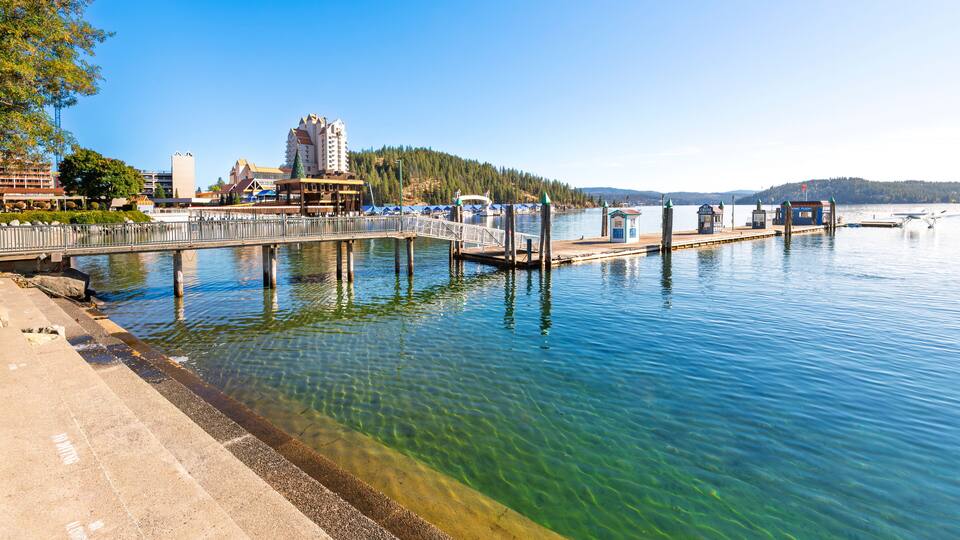 View from the City Beach Park of the wooden pier and jetty with seaplane and the downtown resort and Tubbs Hill, in Coeur d'Alene, Idaho USA.