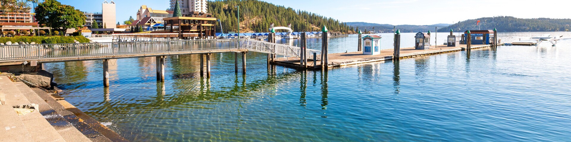 View from the City Beach Park of the wooden pier and jetty with seaplane and the downtown resort and Tubbs Hill, in Coeur d'Alene, Idaho USA.