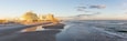 A beach with a hotel and ocean waves.