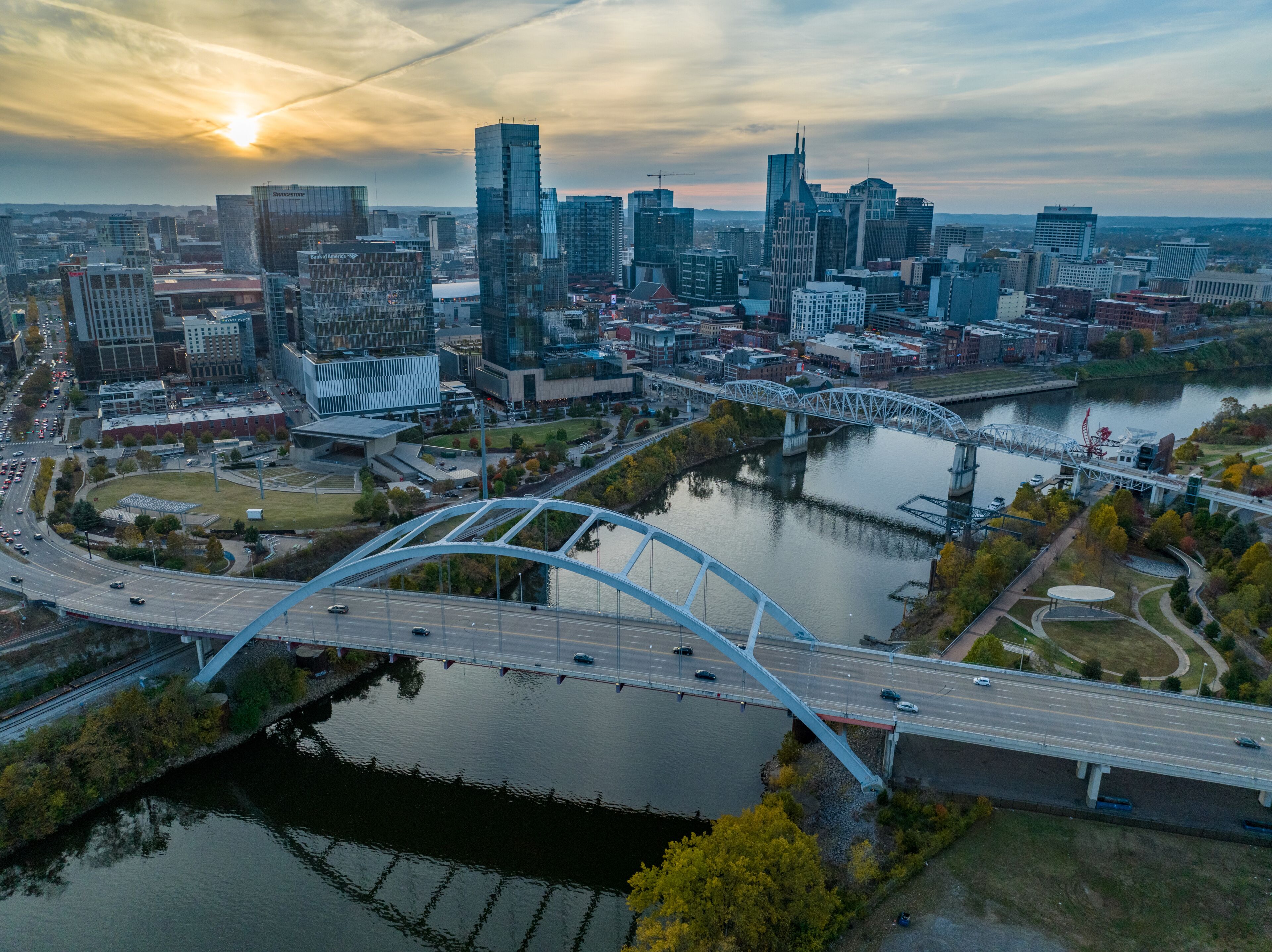 A cityscape with modern skyscrapers, a river, and a distinctive bridge.