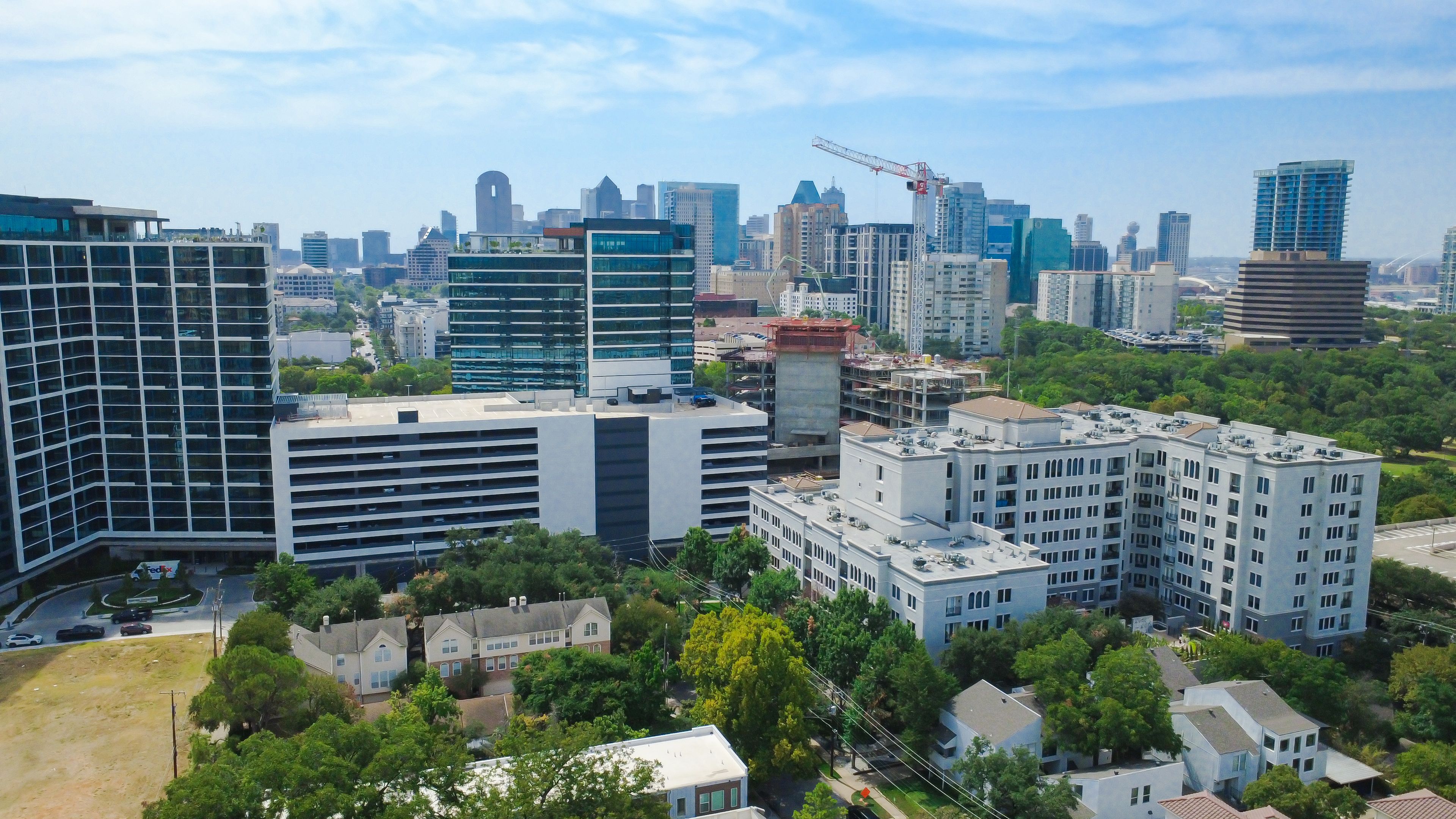 A cityscape with modern buildings, a construction crane, and a mix of residential and commercial structures.