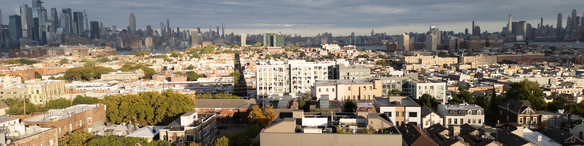 Capturing the urban charm of Jersey City Heights, this aerial view showcases the vibrant residential neighborhoods, tree-lined streets, and a sprawling cityscape. The bustling energy of this area blen