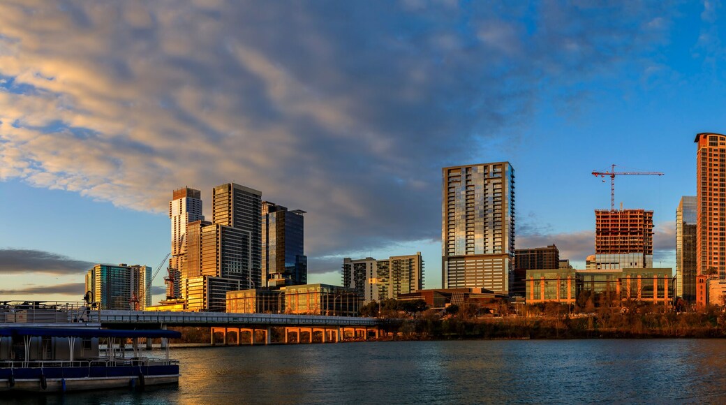 Panorama with downtown view across Lady Bird Lake or Town Lake on Colorado River at sunset golden hour, Austin Texas USA
