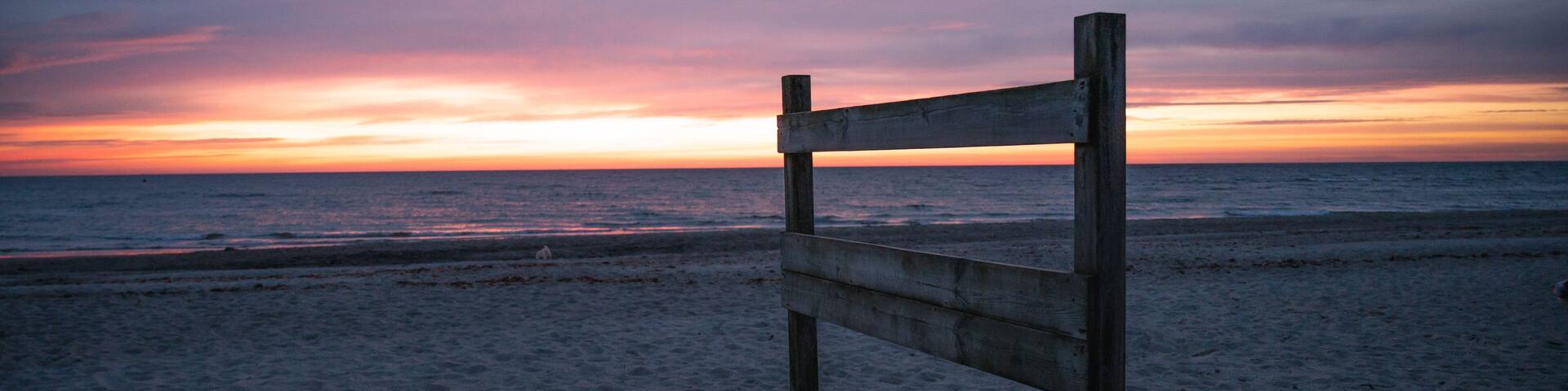 Holzschild am Ostsee strand in olpenitz bei einem gradiosen sonnenaufgang