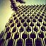A building with a unique geometric facade and a palm tree in the foreground.