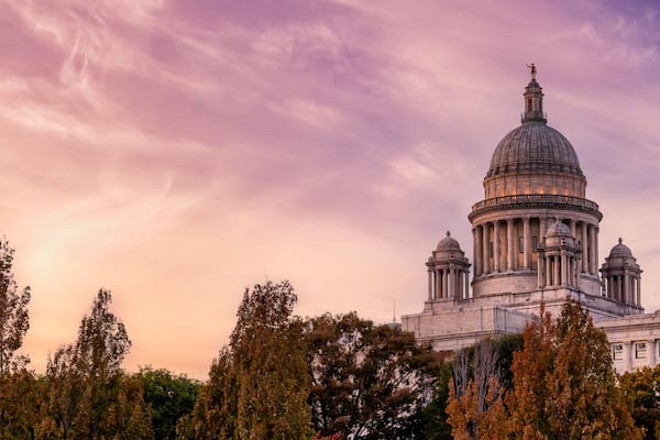 Un grand bâtiment à coupole, orné de colonnes et entouré d’arbres.