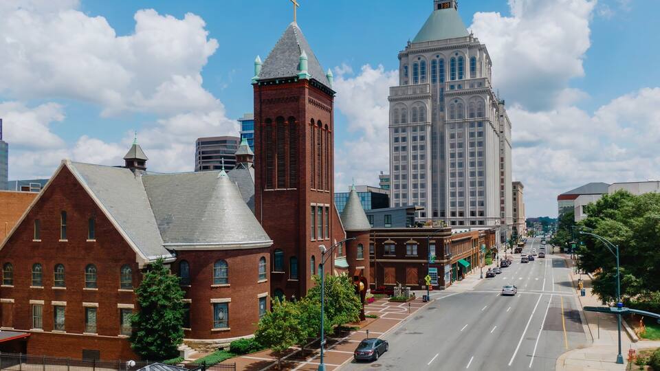A city street lined with historic buildings and a modern skyscraper.