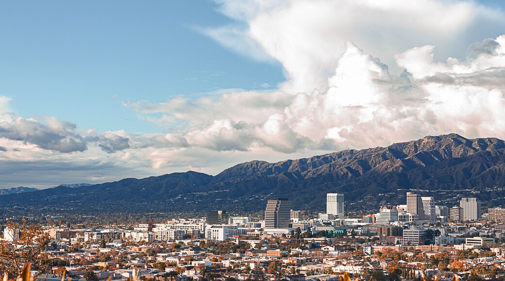 panaramic view of city businesses and homes with hillside homes and mountains