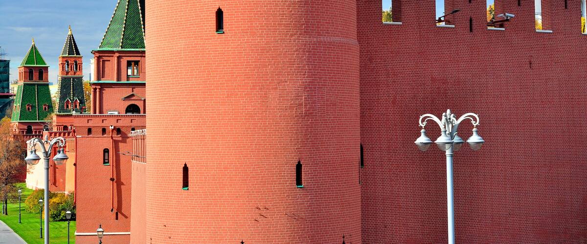 A red brick tower with a golden dome and a white tower with a golden dome.