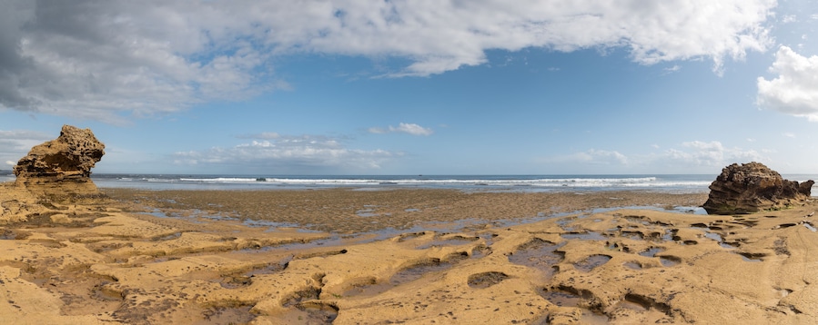 Panorama Rocky beach with rock formations and tidal pools blue sky
