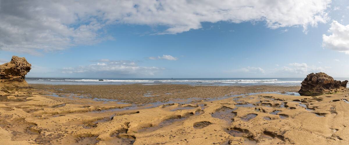 A beach with two prominent rock formations and a sandy shoreline.