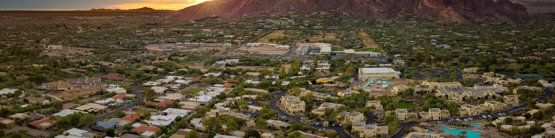 A town with a large mountain in the background and a clear sky.