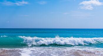 Panorama of a turquoise wave with white foam on a sandy ocean beach in Melbourne Beach, Florida