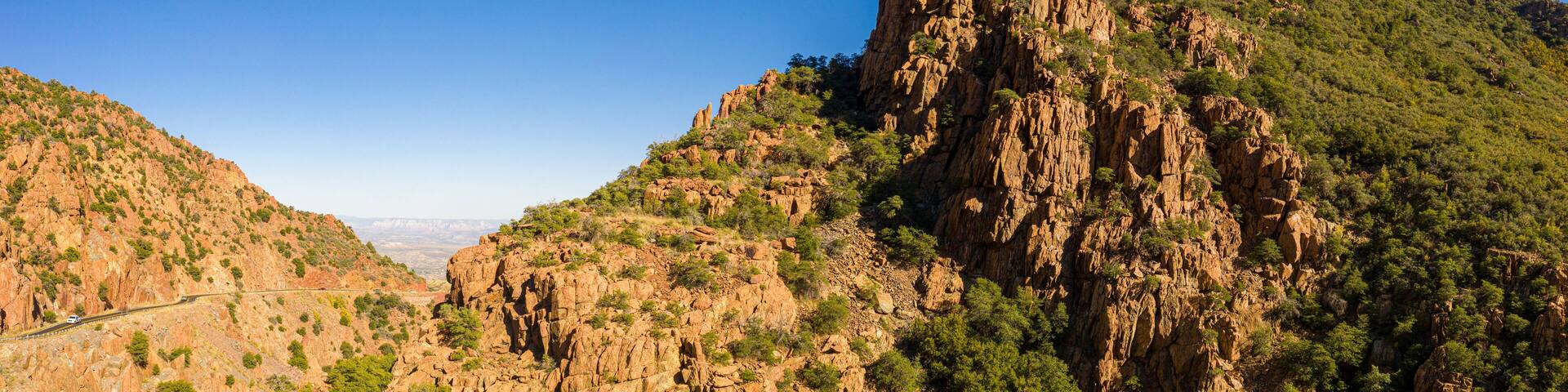 A panorama of a saddle in a mountain in Arizona from a drone with clear blue skies.