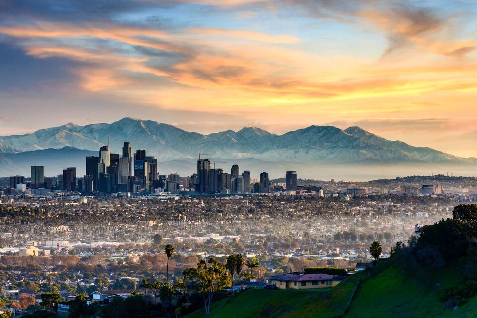 A city skyline with mountains in the background.