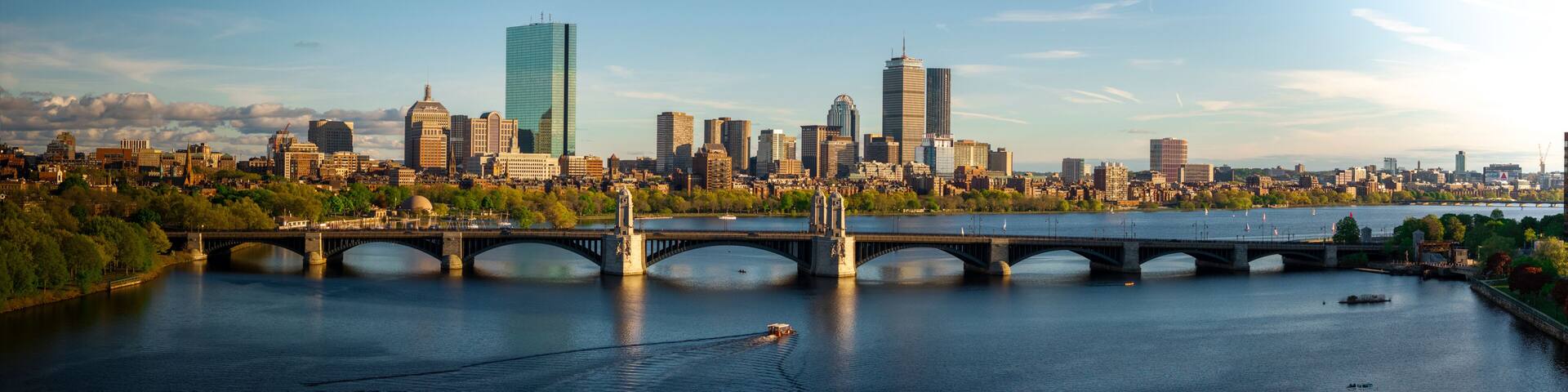 A city skyline with modern skyscrapers, a river, and a bridge.