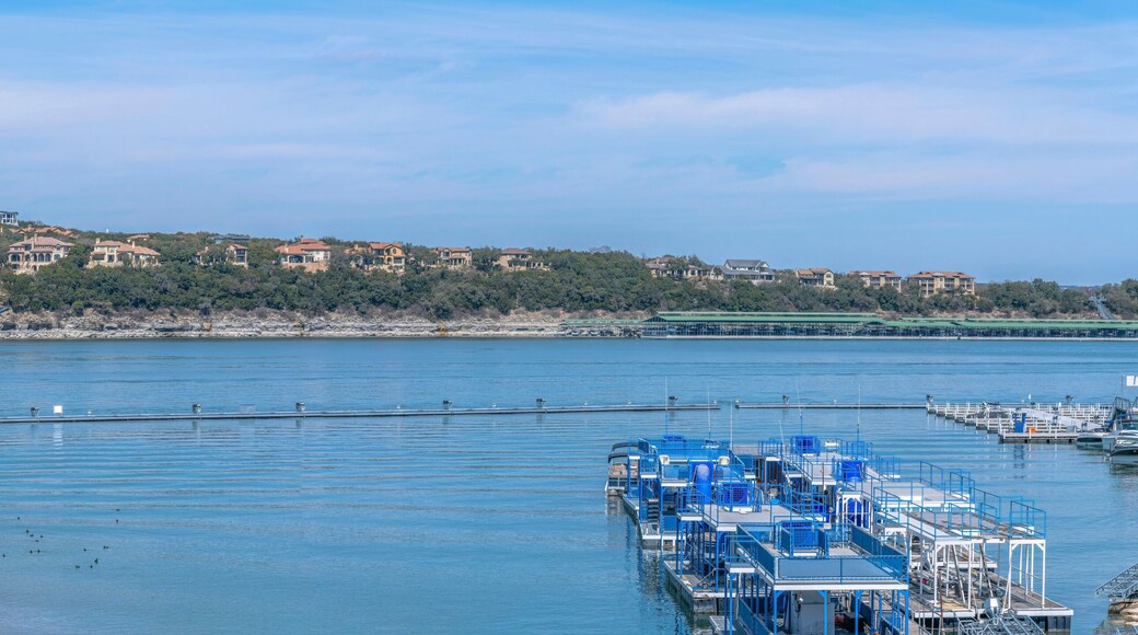 Panoramic view of Lake Austin with docked party boats near residences at Austin, Texas. There are flat boats on the right below near the shore across the sloped residential area across.