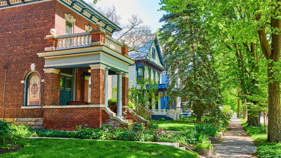 Charming Suburban Street with Victorian and Colonial Houses, Lush Greenery