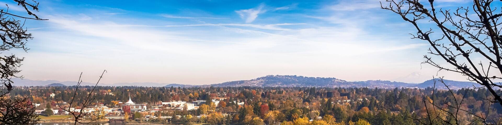 A river winding through a town surrounded by autumn-colored trees.