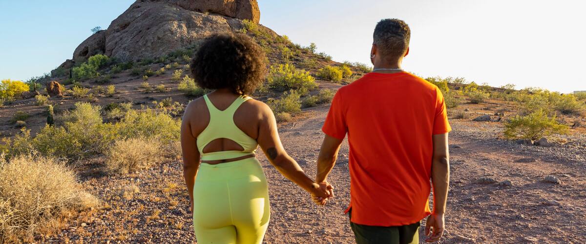 Happy black couple together hiking  view from behind and hands held