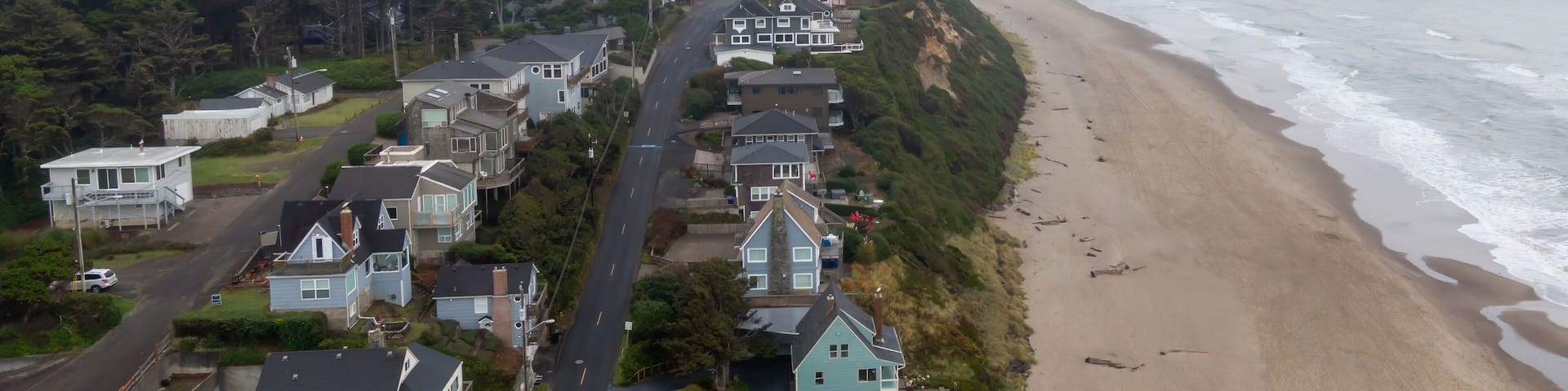 Lincoln City nestled along a foggy beach. Houses line the hillside overlooking the ocean. A tranquil scene of nature and residential life, Oregon, USA