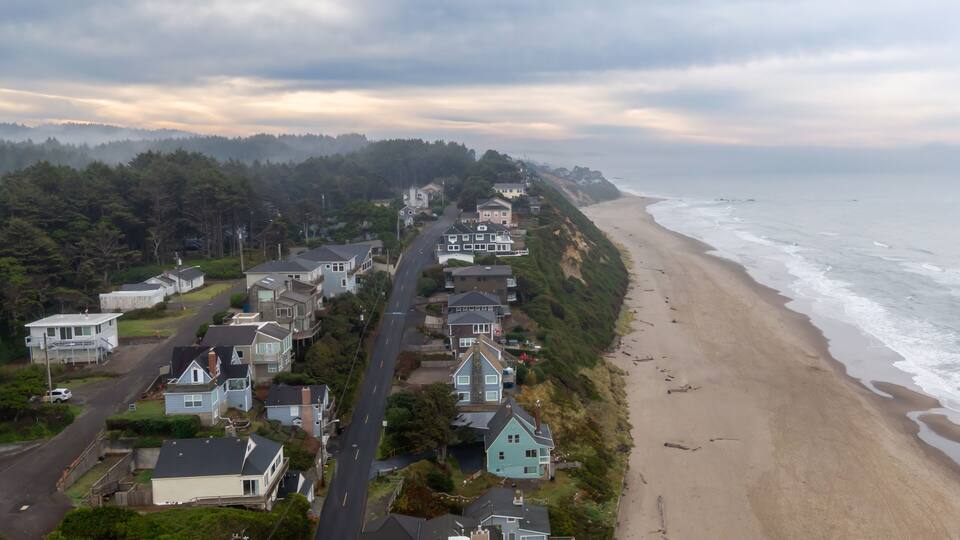 Lincoln City nestled along a foggy beach. Houses line the hillside overlooking the ocean. A tranquil scene of nature and residential life, Oregon, USA