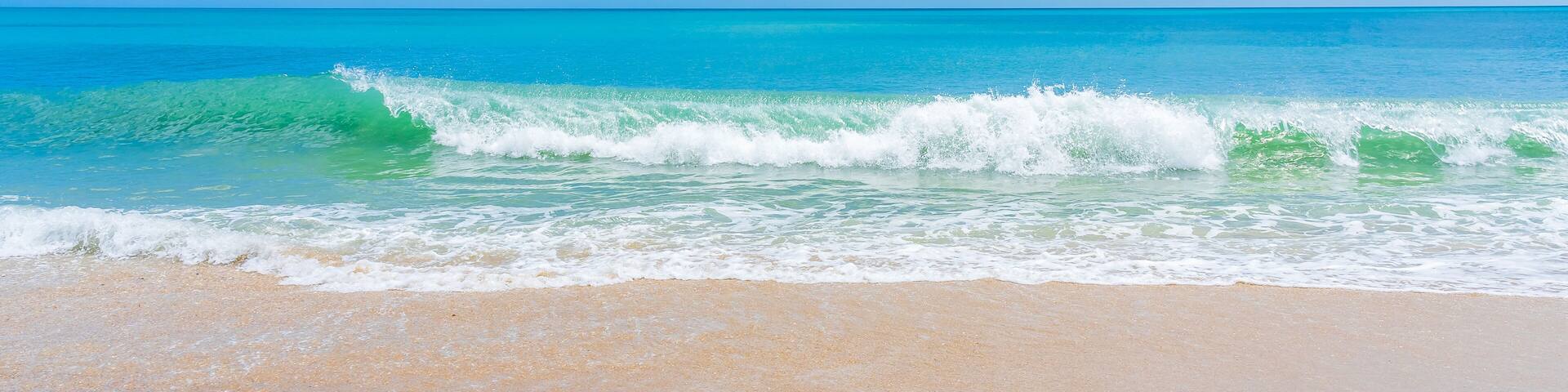 Blue-green wave on ocean beach in Florida in spring. Panoramic photo