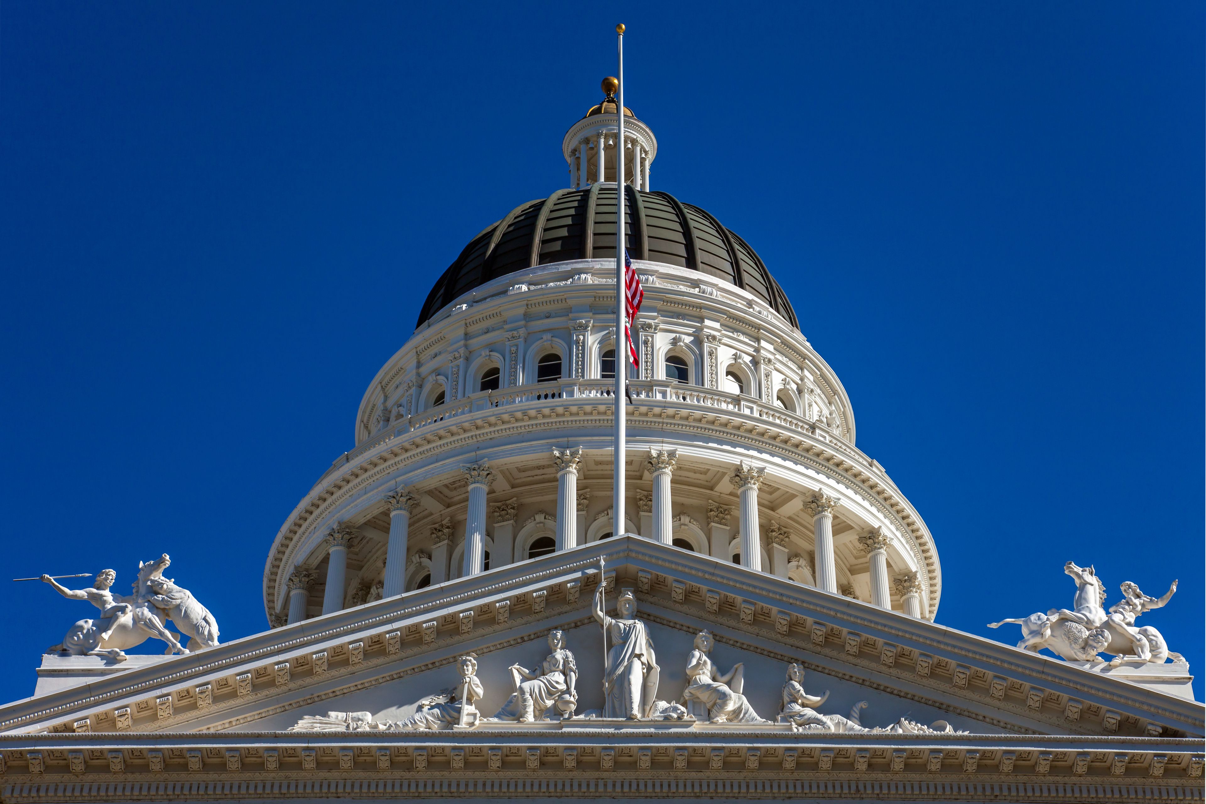 A large domed building with classical architecture, including columns and statues on the front.