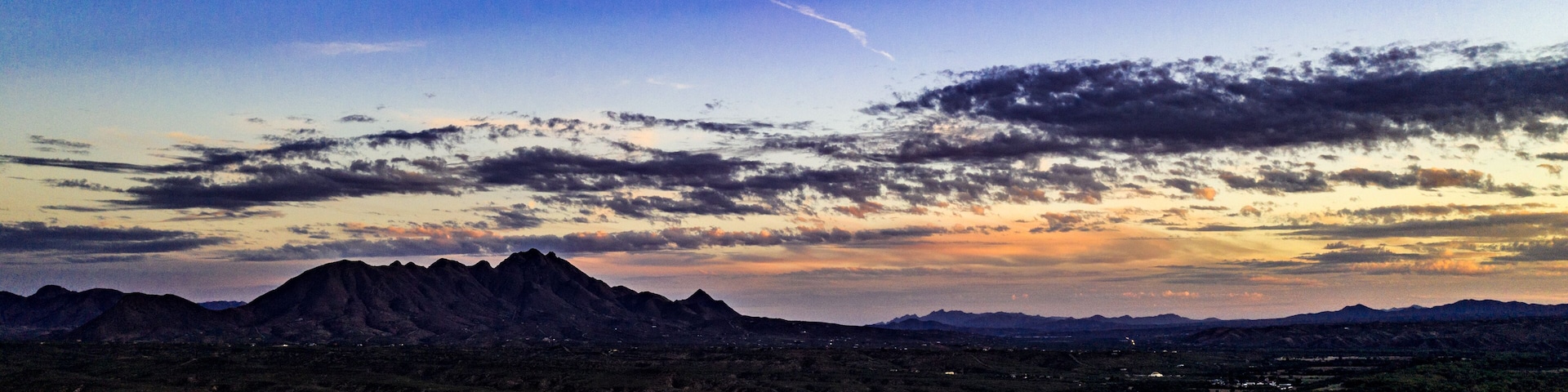 Sunset, aerial landscapes of Santa Rita Mountains from above Tubac, Arizona with warm , golden plains, purple mountains, blue sky with colorful clouds on a Fall day
