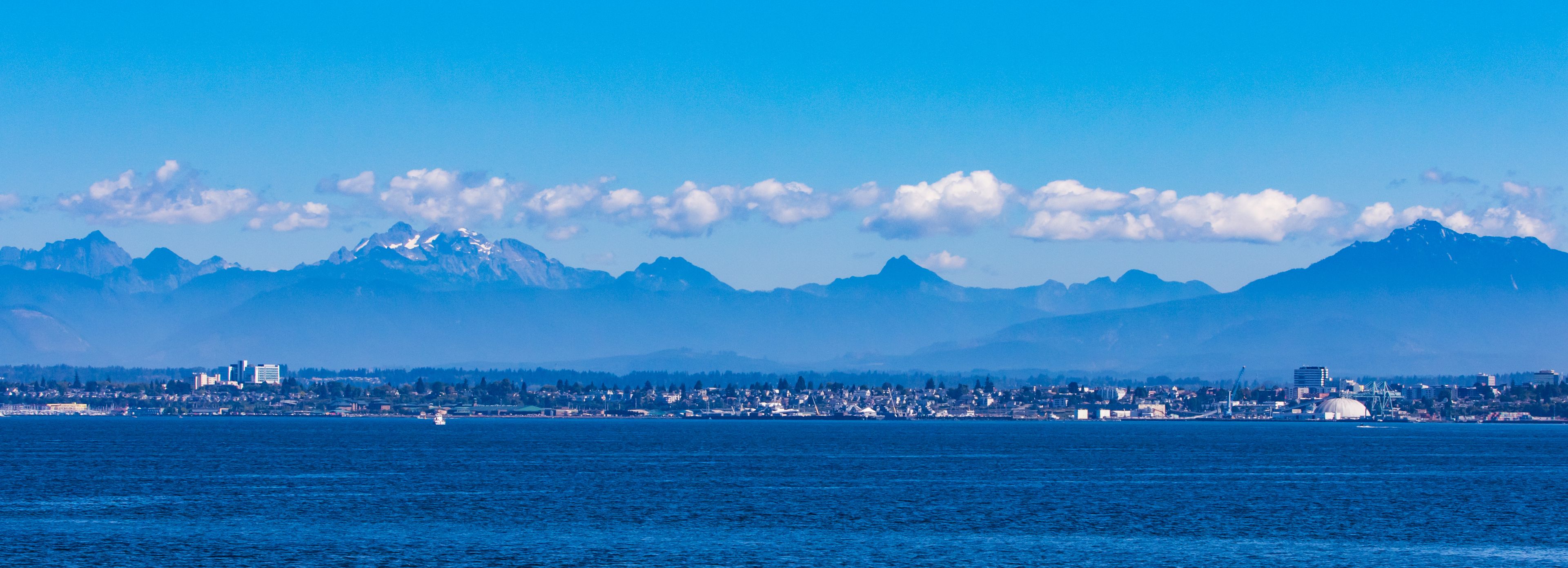 A coastal city with mountains in the background.